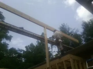 Carpenter setting a ridge beam over a new addition frame — Ice Dam Removal by Roofing Brothers in Potrero